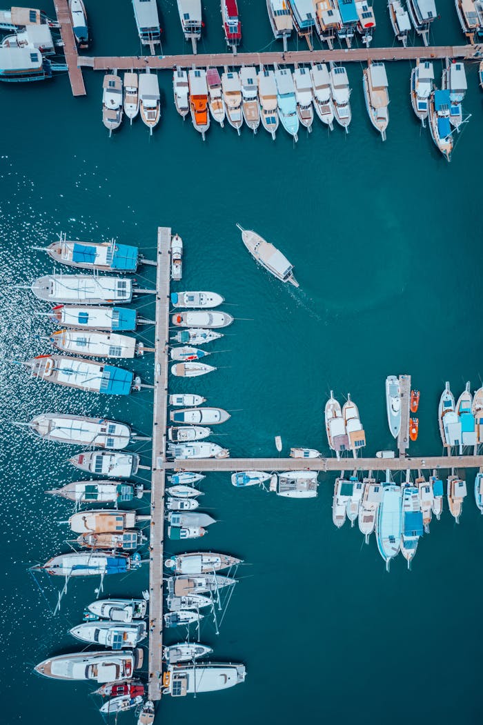 services-06 Drone capture of yachts and boats moored at a serene Antalya harbor, showing an organized vertical display.