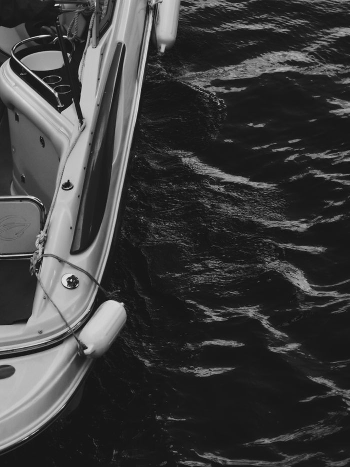 services-header Artistic black and white photo of boat on water showcasing marine travel.